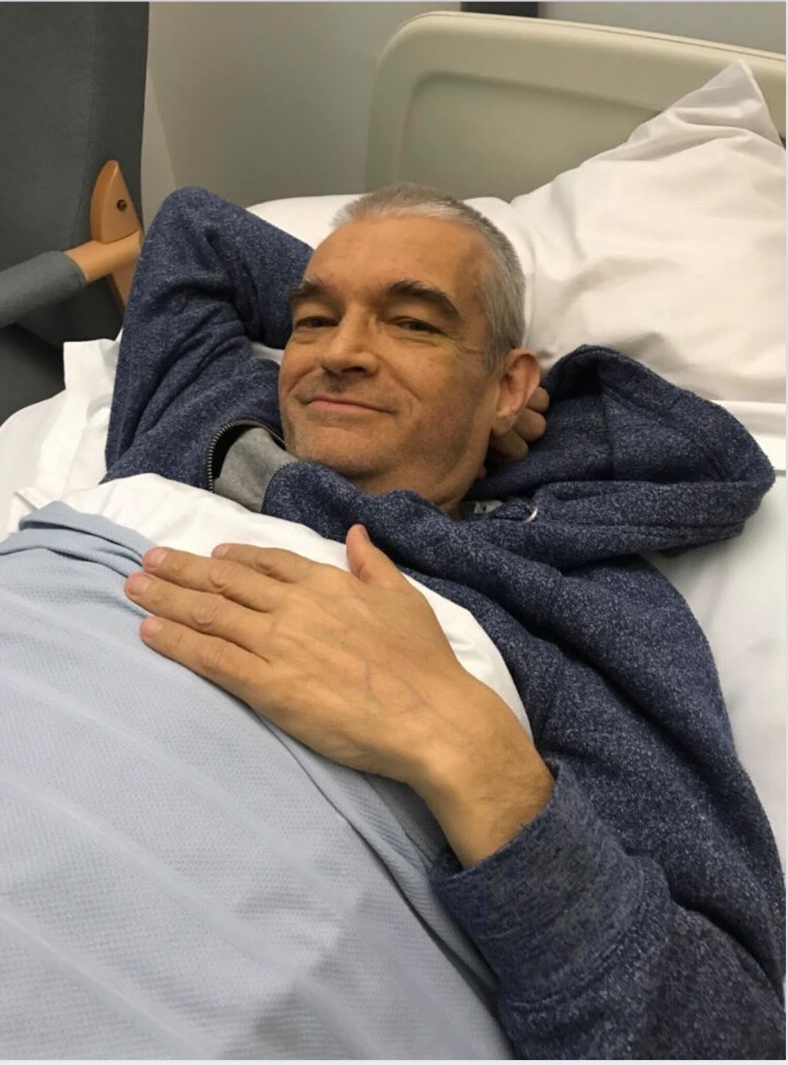 Brian resting in a hospital bed after his liver transplant